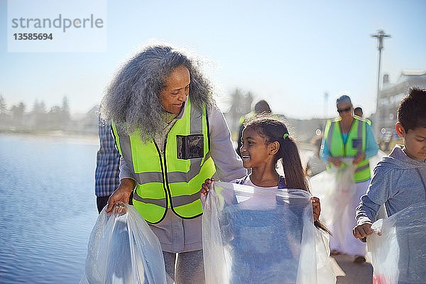 Großmutter und Enkelin sammeln freiwillig Müll an der Strandpromenade auf