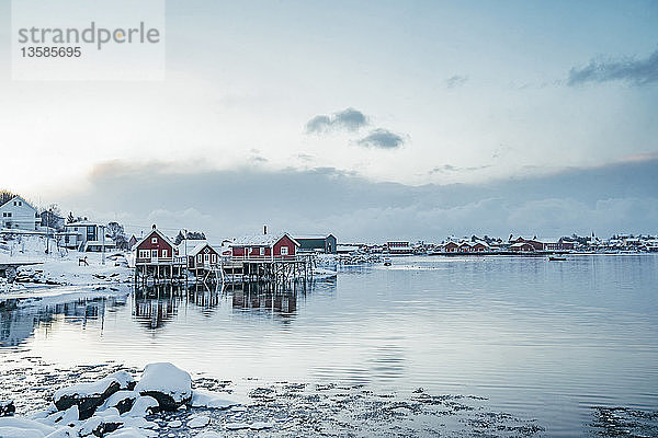 Ruhiger Blick auf verschneites Fischerdorf am Wasser  Reine  Lofoten-Inseln  Norwegen