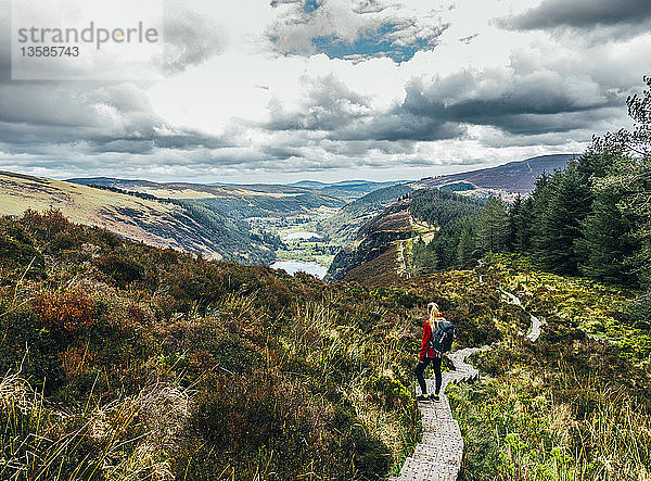 Frau beim Wandern auf einem idyllischen Bergpfad mit Blick auf eine malerische Landschaft  Wicklow NP  Irland