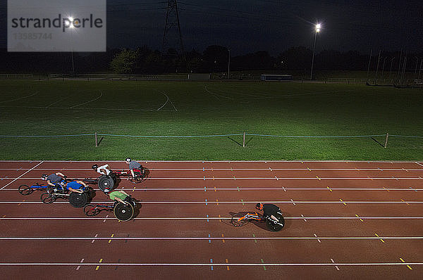 Querschnittsgelähmte Athleten rasen bei einem nächtlichen Rollstuhlrennen über eine Sportstrecke