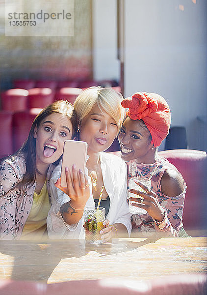 Silly  spielerische junge Frauen Freunde nehmen Selfie mit Kamera-Handy im Café