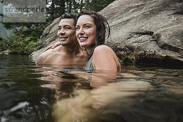 Zärtliches junges Paar beim Schwimmen im See