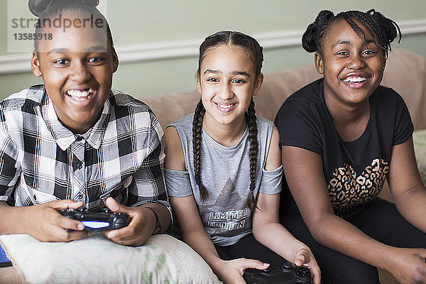 Portrait lächelnd tween Mädchen Freunde spielen Videospiel auf Sofa