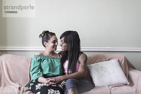 Zärtliches lesbisches Paar auf dem Sofa