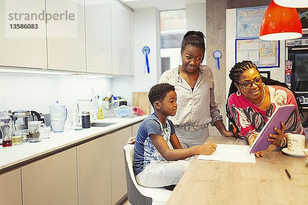 Familie mit digitalem Tablet in der Küche