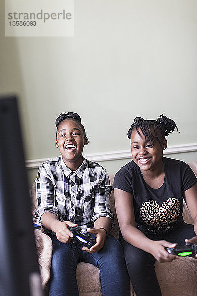 Glückliche Tween Mädchen Freunde spielen Videospiel im Wohnzimmer