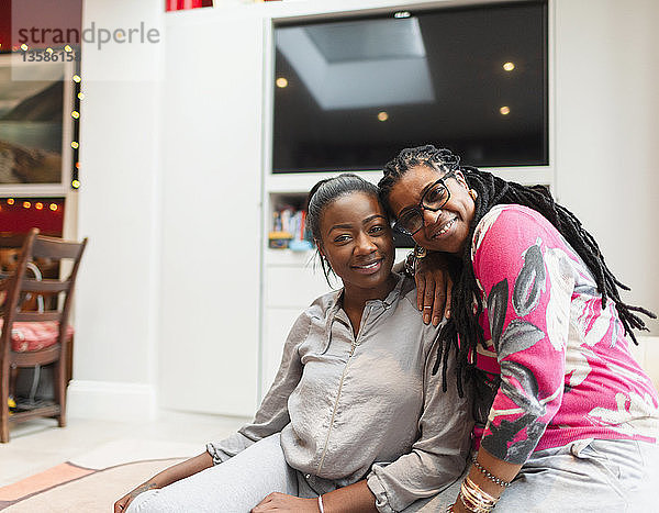 Porträt glückliche Mutter und erwachsene Tochter im Wohnzimmer
