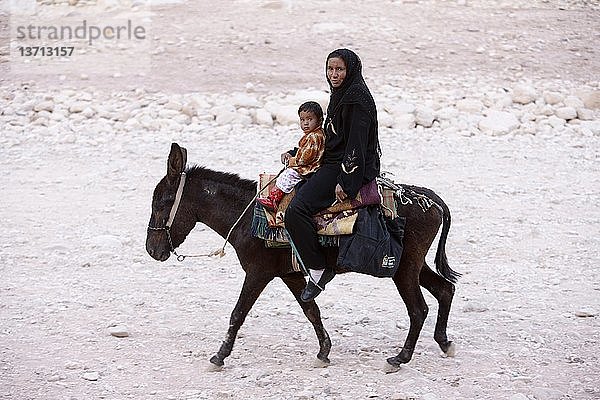 Beduinenfrau und Kind auf einem Esel in Petra   Petra  Jordanien.