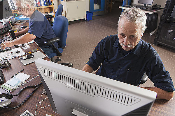 Zwei Ingenieure arbeiten an Computern in einem Kontrollzentrum