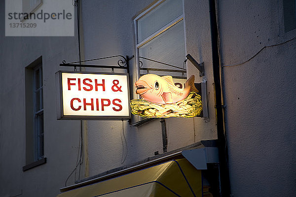 Beleuchtetes Schild einer Fisch- und Pommesbude bei Nacht  Harwich  Essex