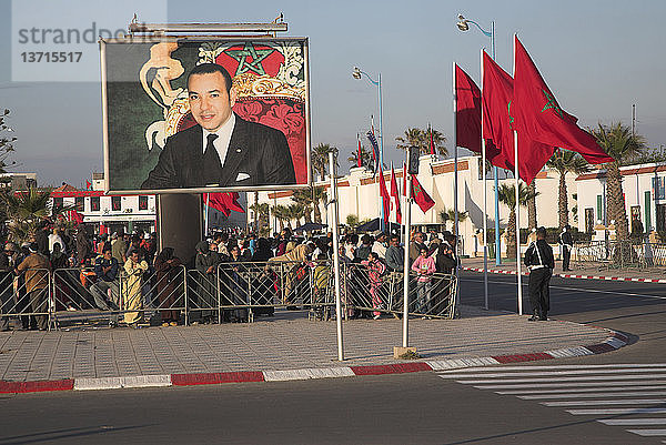 Menschenmenge auf der Straße mit Fahnen und großem Plakatbild König Mohammeds  Essaouira  Marokko