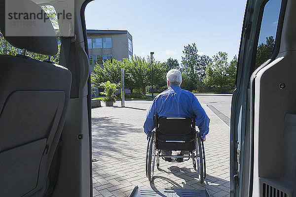 Mann mit Muskeldystrophie und Diabetes steigt aus einem behindertengerechten Lieferwagen aus