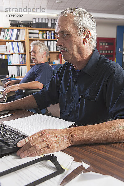 Zwei Ingenieure arbeiten an Computern in einem Kontrollzentrum