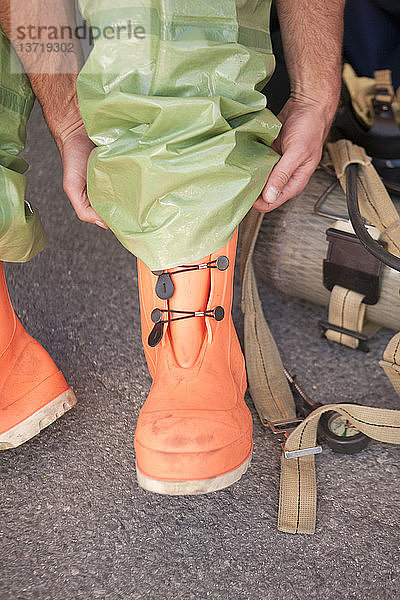 HazMat-Feuerwehrmann beim Anziehen der Schutzstiefel