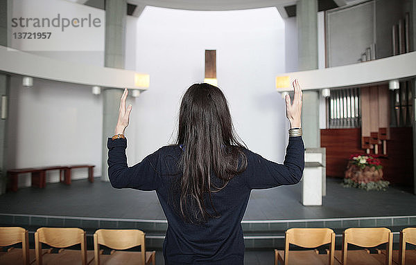Junge Frau beim Gebet in einer Kirche.