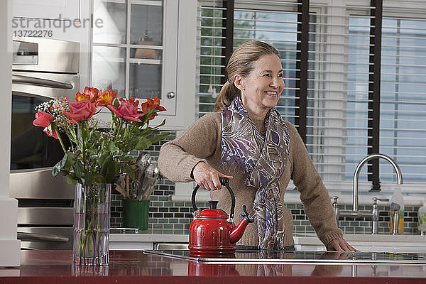 Eine ältere Frau benutzt einen energieeffizienten Herd in der Küche eines Green Technology Home