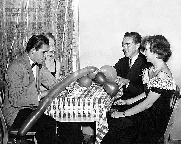 Vereinigte Staaten: 1947 Zwei Paare versuchen  sich auf einer Party mit Luftballonspielzeug zu amüsieren.