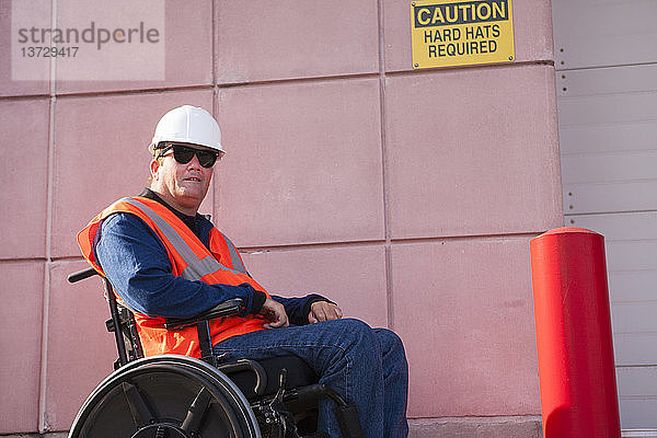 Gebäudetechniker im Rollstuhl im Bereich des Schutzhelms