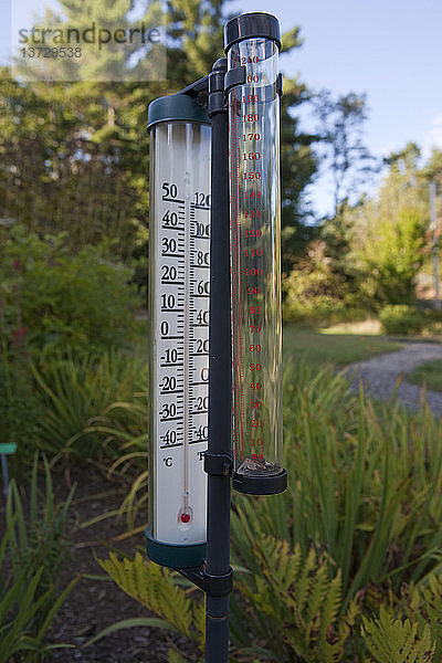 Thermometer und Regenmesser in einem Garten