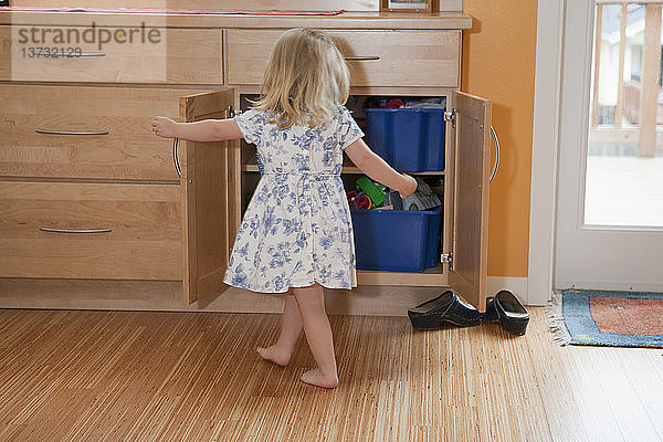 Mädchen sucht in einem Kleiderschrank einer behindertengerechten Wohnung