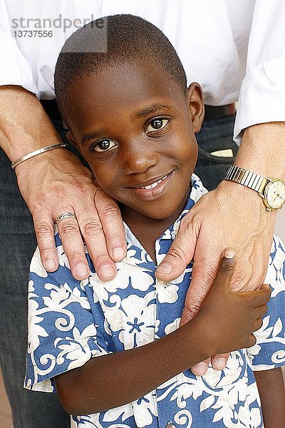 Haitianisches Kind hält eine weiße Hand  Port-Au-Prince  Haiti.