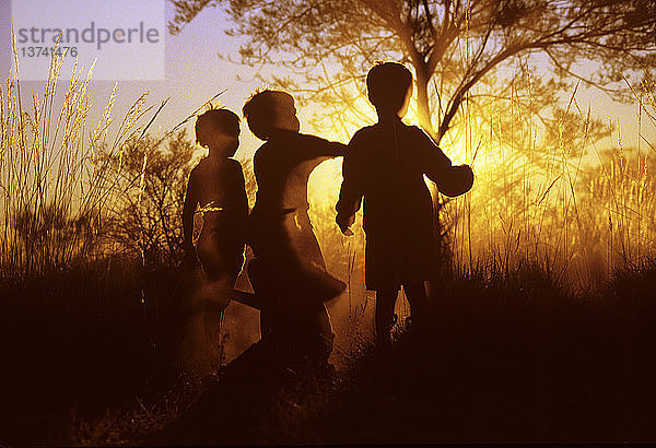 Aborigine-Kinder in Silhouette bei Sonnenuntergang auf der Canning Stock Route  Little Sandy Desert  Westaustralien