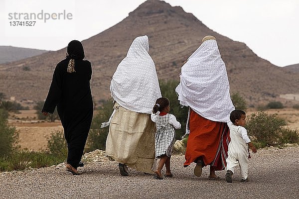 Frauen und Kinder in einem Dorf gehen auf einer Landstraße  Tunesien.