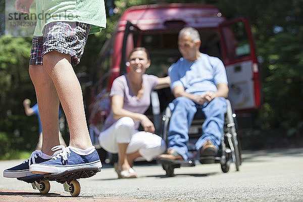 Ehepaar beobachtet seinen Sohn auf dem Skateboard