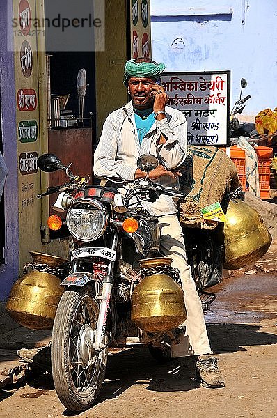 Milchsammler mit Milchkannen auf seinem Motorrad.