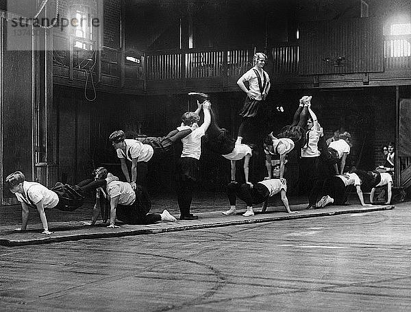 Cambridge  Massachusetts: ca. 1926 Mädchen der Sargent School for Physical Education bauen eine Pyramide für ihre bevorstehende Show in der Boston Arena.