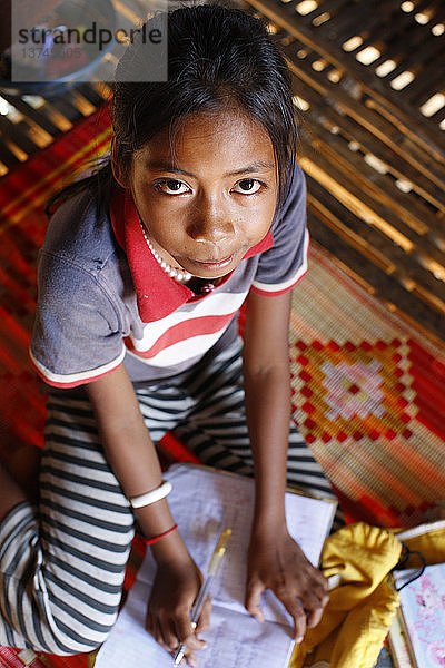Junges kambodschanisches Mädchen macht ihre Hausaufgaben
