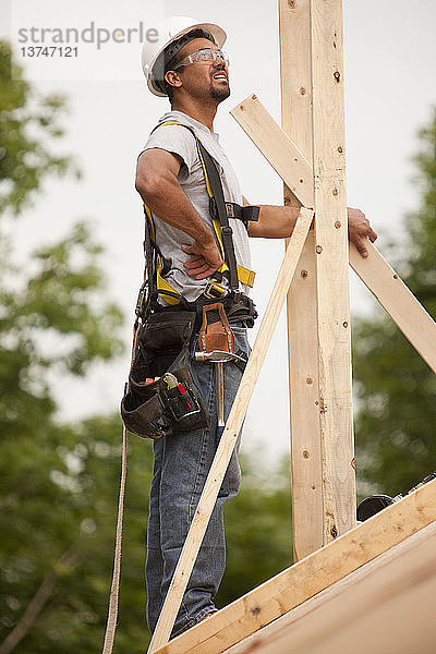 Spanischer Zimmermann bei der Prüfung von Schornsteinpfosten an einem im Bau befindlichen Haus