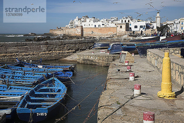 Blaue Fischerboote und weiße Medinamauern vom Wasser aus  Essaouira  Marokko