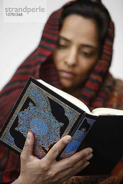 Frau liest Kuran