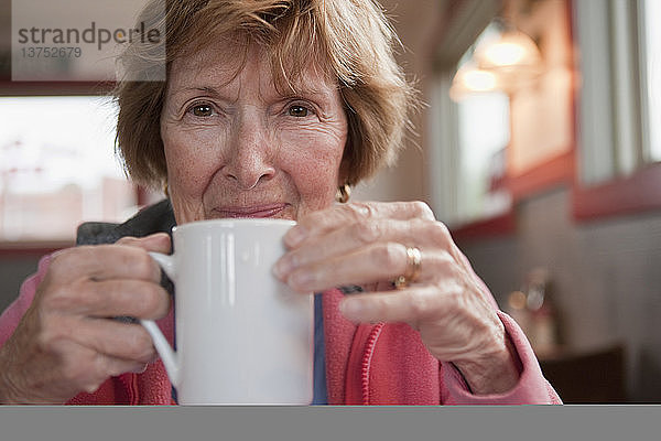 Frau trinkt eine Tasse Kaffee in einem Cafe