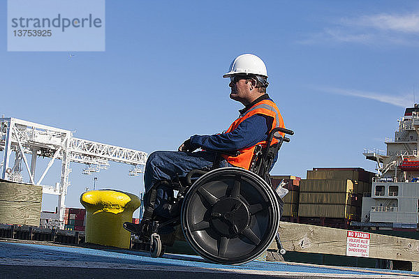 Transportingenieur im Rollstuhl bei der Inspektion von Schiffscontainern im Verschiffungshafen