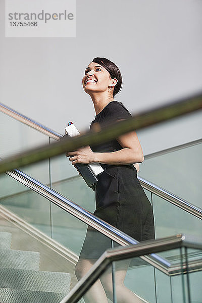 Geschäftsfrau geht die Treppe eines Bürogebäudes hinauf
