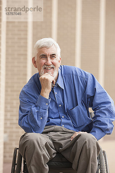 Mann mit Muskeldystrophie und Diabetes lächelt in seinem Rollstuhl