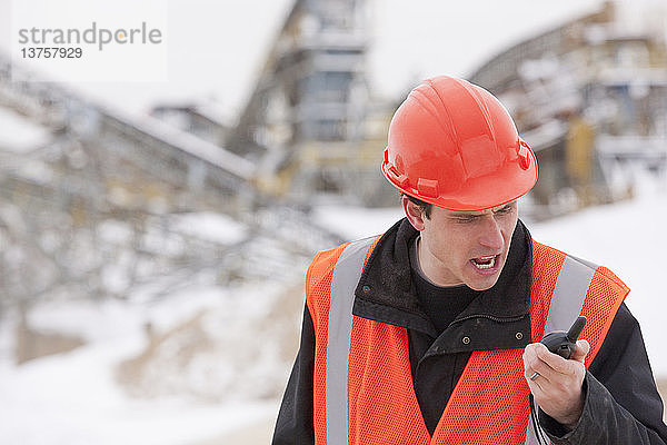 Ingenieur schreit in ein Walkie-Talkie