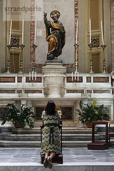 Frau betet in der Kirche zum Heiligen Petrus