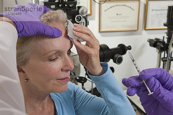 Augenarzt gibt einem Patienten eine Botox-Injektion