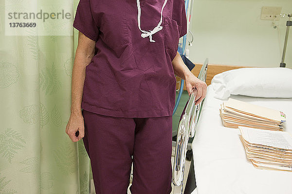 Eine Krankenschwester steht neben einem Krankenbett in einem Krankenhaus