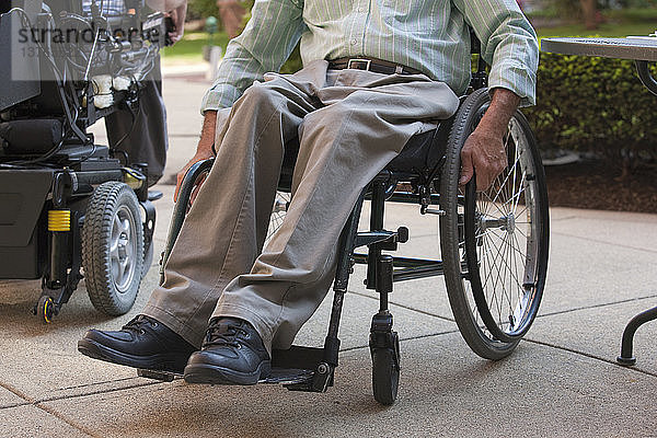 Ein Mann mit einer Rückenmarksverletzung sitzt im Rollstuhl