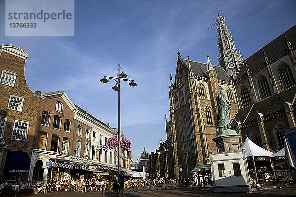Menschen sitzen vor Café Haarlem Holland