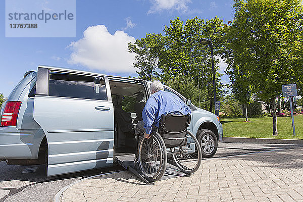 Ein Mann mit Muskeldystrophie und Diabetes steigt in einen barrierefreien Kleinbus ein