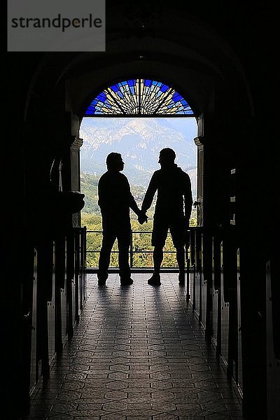 Silhouette eines schwulen Paares am Ausgang der Kirche.