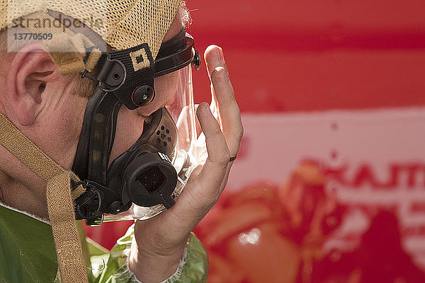 HazMat-Feuerwehrmann beim Anlegen der Maske und Überprüfen der Dichtigkeit