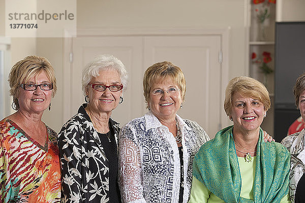 Porträt von vier älteren Freundinnen  die zusammen lächeln