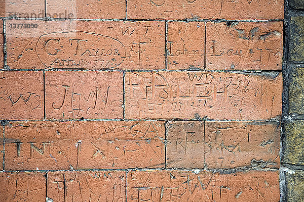 Graffiti aus dem achtzehnten Jahrhundert an der Backsteinwand eines Schulgebäudes in Dedham  Essex