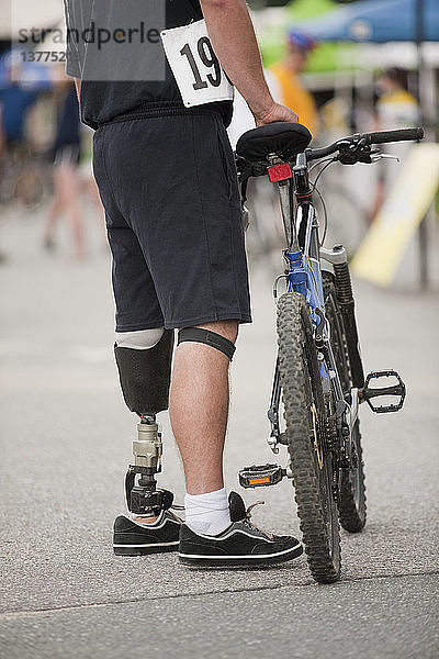 Mann mit Beinprothese bei einem Radrennen